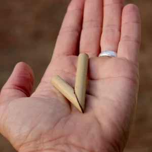 A close-up of a hand holding a Colibri Healing kuripe in the palm.